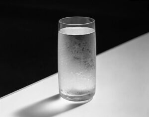 Close-up of a perfectly clear glass filled with pure water, ready for drinking, representing health and wellness.